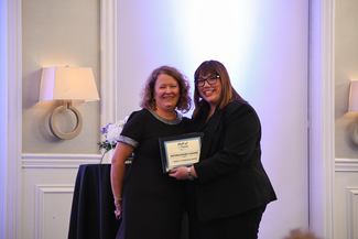 a photograph of Robin Vanderpool recieving the Distinguished Leader award
