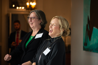 a photograph of two people laughing at the event