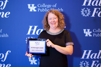 a photograph of Robin Vanderpool holding their award