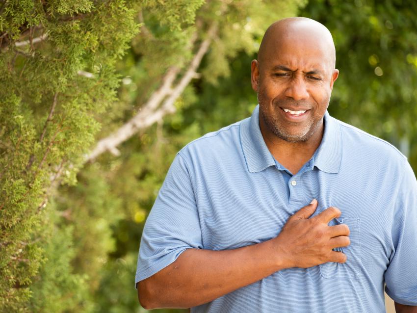 a photograph of an African American male holding hand over heart