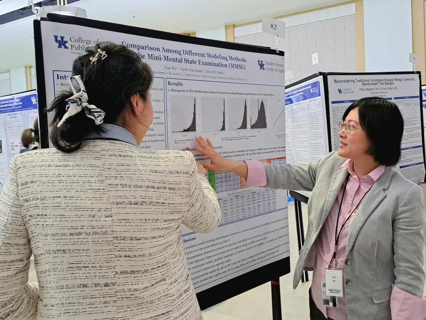 Students standing in front of a research poster discussing findings