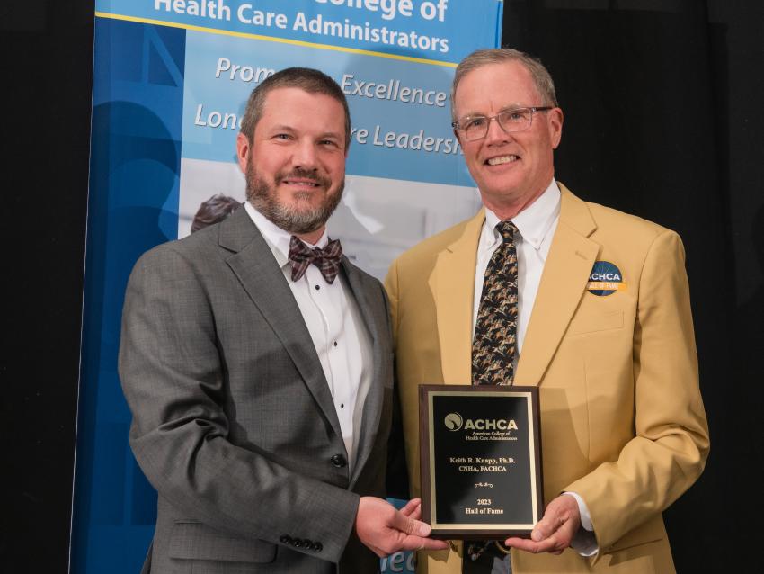 Dr. Keith Knapp (right) receiving plaque award & gold blazer from board chair Matt Lessard (left)