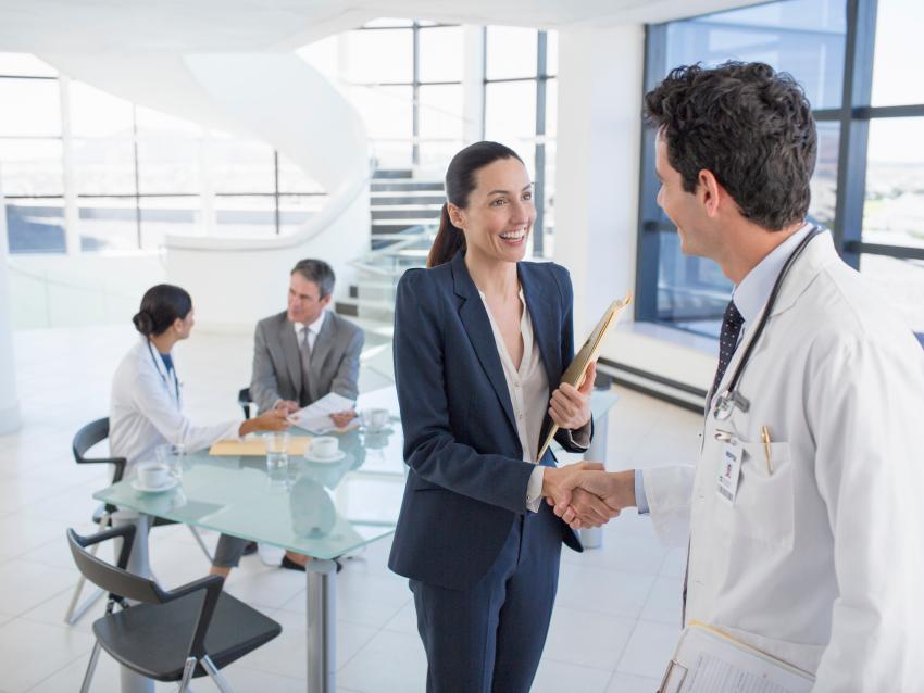 Businesswoman and doctor handshaking in meeting