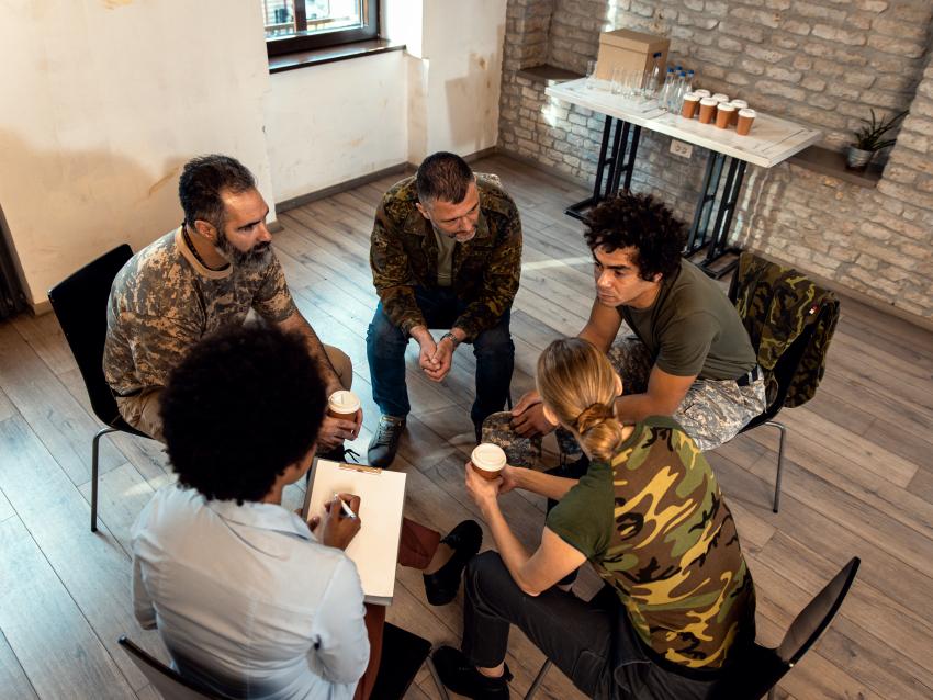 Group of diverse veterans talking during PTSD support group