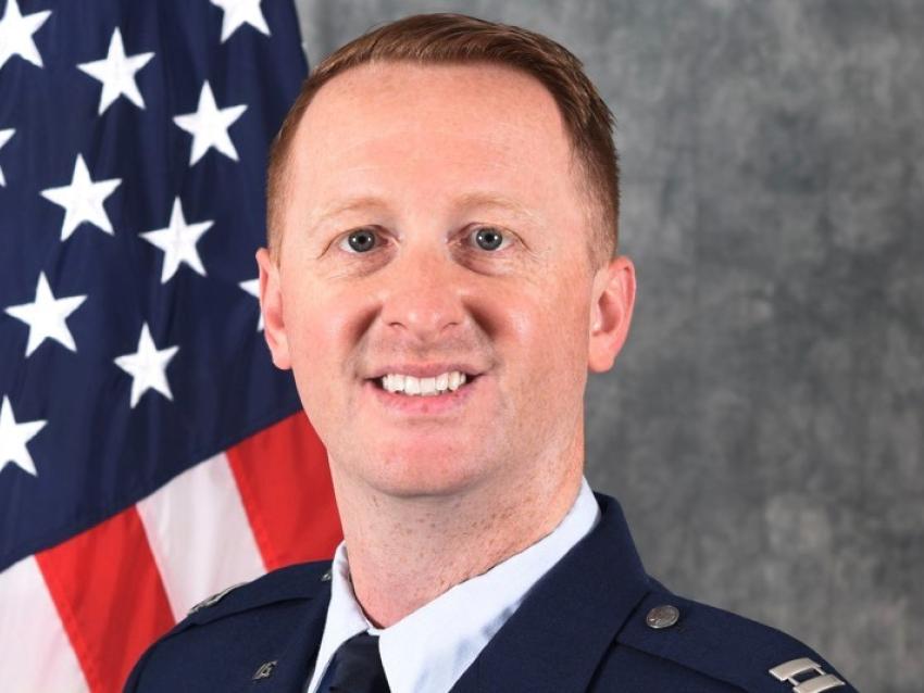 Professional picture of Maj. Marcus Hincks in Air Force uniform in front of the US flag
