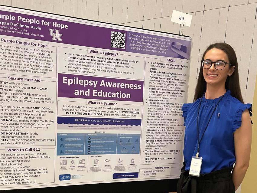 Morgan DeChene pictured in front of research poster about epilepsy awareness and education
