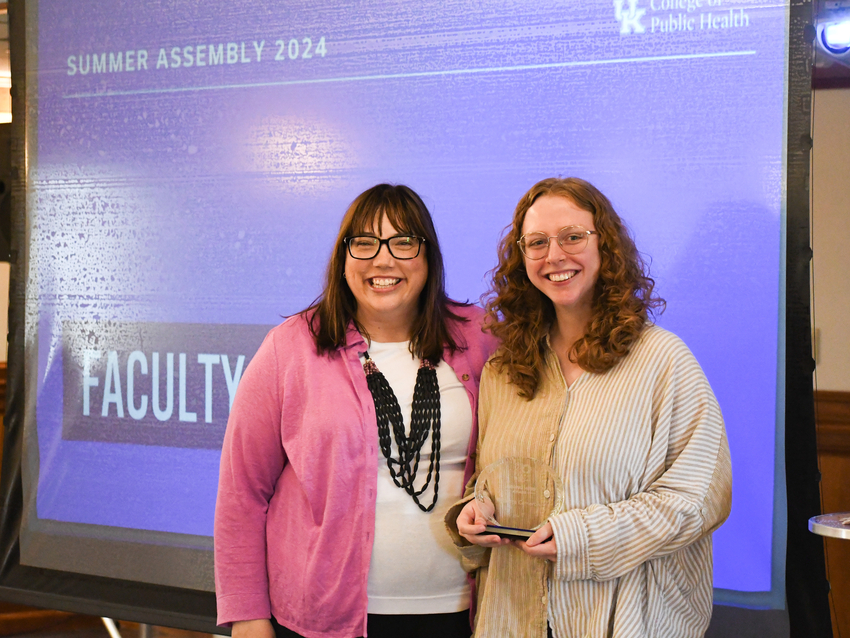 a photograph of Rebecca Cameron accepting her award from Dean Bush