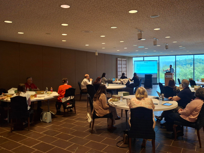 a photograph of Dr. Charbel Salem presenting to action team members to review data from colorectal screenings 