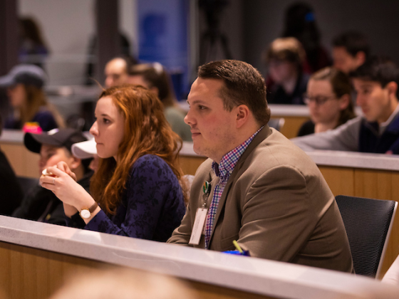 a photograph of students sitting in an auditorium classroom