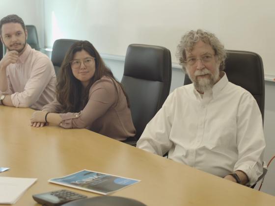 a photograph of Dr. John Lyons, Diamond Darling and Brian Turner at a conference table