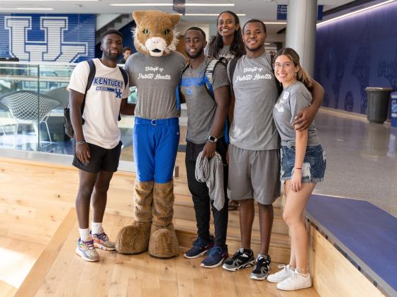 a photograph of students posing with the University of Kentucky wildcat mascot