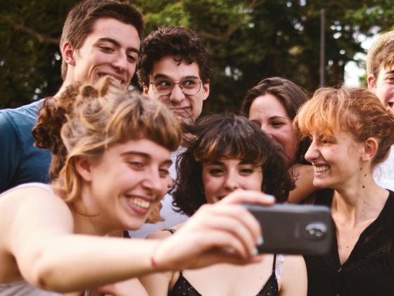 a photograph of a group of young people gathering for a selfie